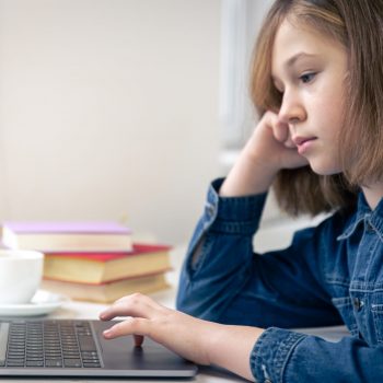 teen-girl-sits-in-front-of-laptop-online-learning